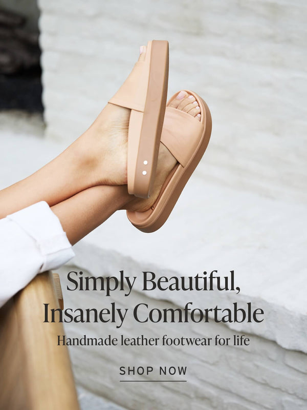 Woman wearing Chick leather slide sandals in beach with white pants with text overlay: "Simply Beautiful, Insanely Comfortable, Handmade leather footwear for life" and Shop Now button