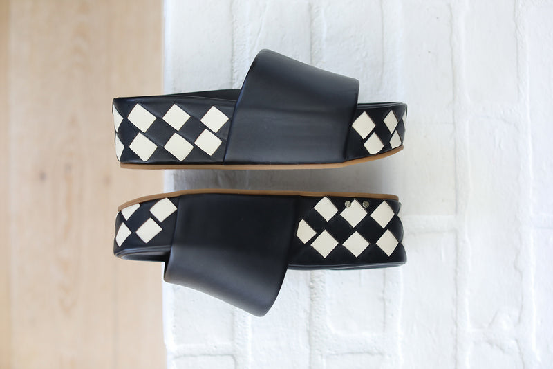 Product shot of Albatross Woven leather platform sandal in eggshell/black against the wall