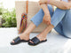 Woman wearing Baza leather slide sandals in black with jeans