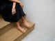 Woman wearing Baza leather slide sandals in honey with black dress.