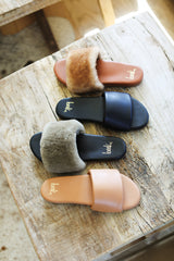 Group shot of Baza leather slides in honey and black with Baza Shearling slide sandal in bronze/black and honey/tan.