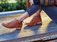 Woman wearing Falcon leather booties in cognac with jeans and sweater.