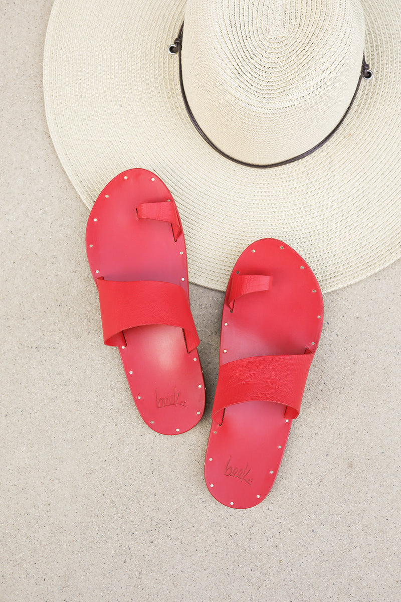 Finch leather toe-ring sandal in lipstick next to hat