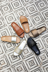 Group shot of Gallito leather slide sandals in metallic mocha, black, platinum, platinum/beach, tan, and honey