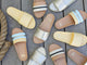 Group shot of Gallito leather slide sandals in glow, platinum/beach, platinum with Gallito Stripe sandals in eggshell/beach and sky/beach