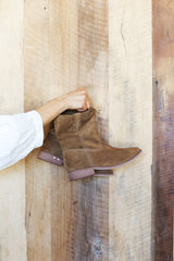 Woman holding Grouse slouchy leather boot in chestnut