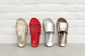 Group shot of Harpy leather slide sandals in gold and lipstick with Starling leather slide sandals in silver and bronze.