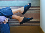 Woman wearing Hen leather platform criss-cross sandals in black with jeans and purple sweater