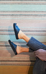 Woman wearing Hen leather platform criss-cross sandals in black with jeans and purple sweater