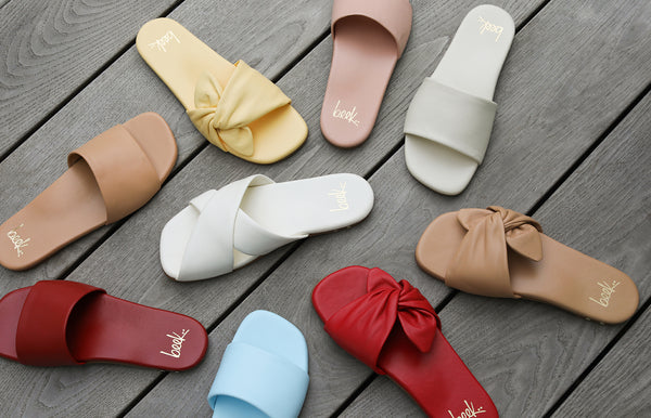 Group shot of Honeybird leather slide sandals in sky, red, beach, and blush with Fernbird leather slide sandals in vanilla and Sweetbird leather slide sandals in lipstick and glow.