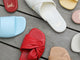 Group shot of Honeybird leather slide sandals in sky, red, beach with Fernbird leather slide sandals in vanilla and Sweetbird leather slide sandals in lipstick and glow.