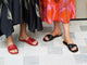 Women wearing Honeybird leather slide sandals in red and Whipbird leather slide sandal in black