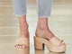 Woman wearing Ibis leather platform heel sandals in beach with light jeans