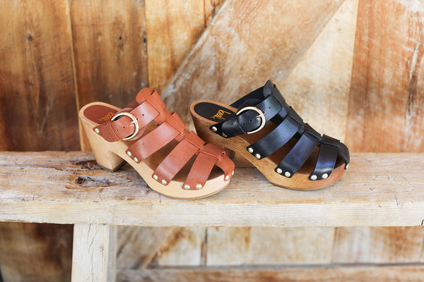 Group shot of Magpie leather heeled clogs in black and cognac