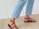 Woman wearing Miner ankle strap leather sandals in tan with jeans