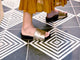 Woman wearing Pelican leather platform sandals in bronze/black with dress