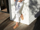 Woman wearing Pelican leather slide sandals in honey with white jeans.