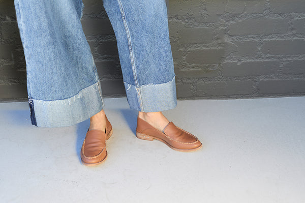 Woman wearing Group shot of Pepper leather loafer in cognac with jeans.