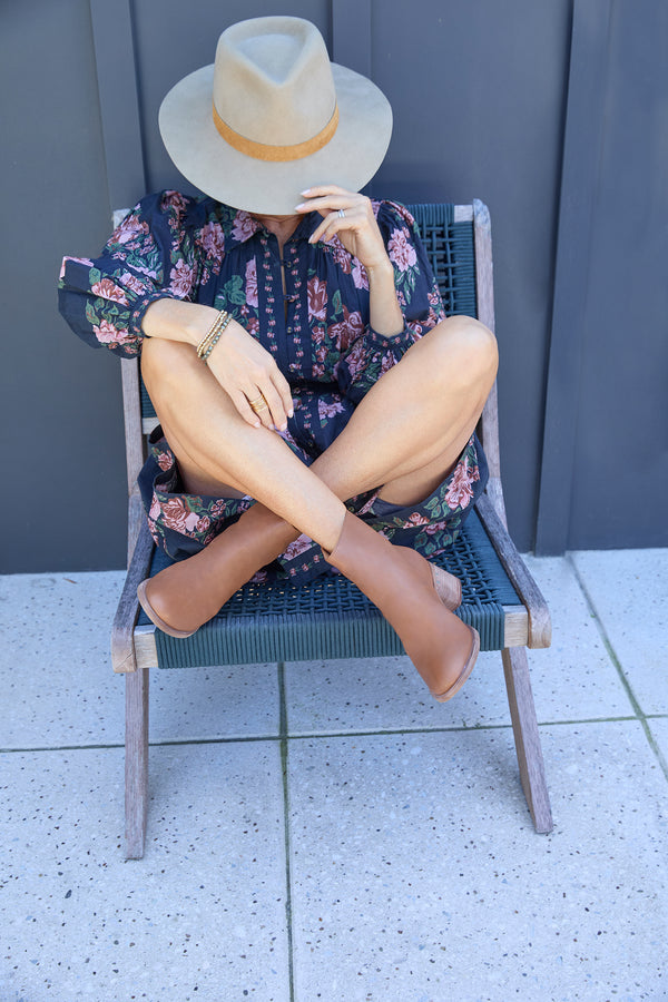 Woman wearing Pheasant leather boots in cognac with floral outfit and hat