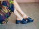 Woman wearing Prinia leather platform heel sandal in black with colorful dress