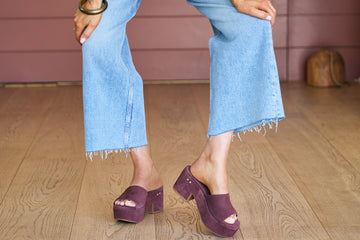 Woman wearing Prinia suede platform heel sandal in plum with jeans and white blouse