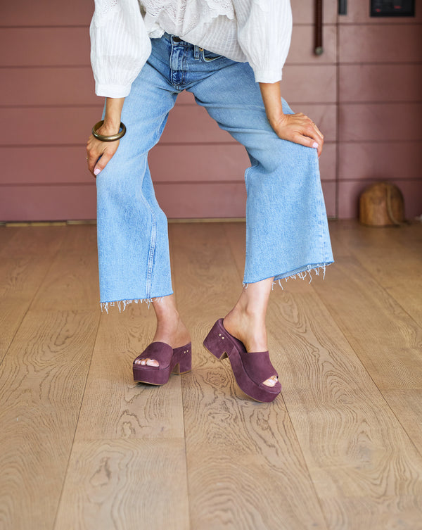 Woman wearing Prinia suede platform heel sandal in plum with jeans and white blouse
