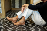 Woman wearing Puffin leather bootie in saddle with white pants