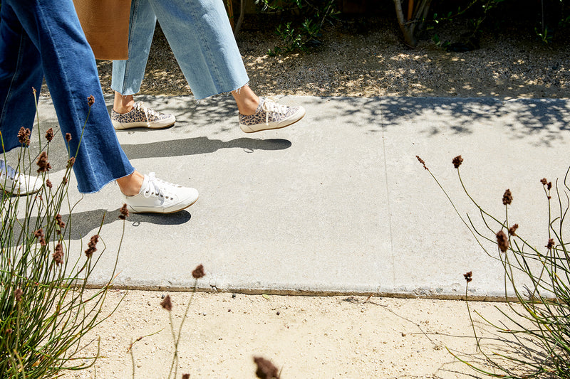 Women wearing Sandpiper sneakers in leopard and white with jeans