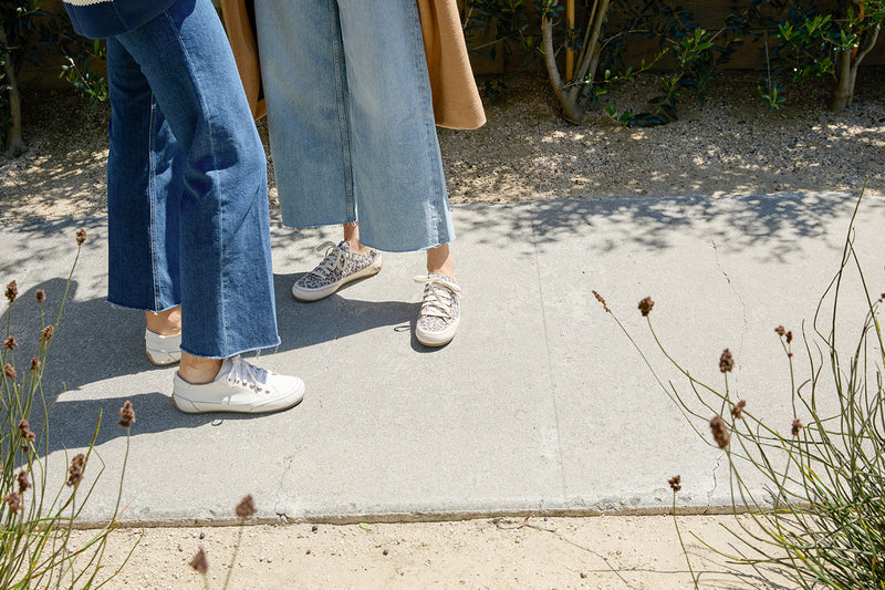 Women wearing Sandpiper sneakers in leopard and white with jeans