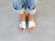 Woman wearing Starling leather slide sandal in silver with cuffed jeans