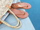 Sunbeam leather flip flop sandal in tan in woven bag by the pool.