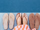 Woman wearing Sunbeam leather flip flop sandal in tan with striped dress next to Sunbeam flip flop sandals in beach and rose gold.