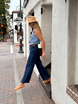 @abbiecrane wearing Swiftlet leather ballet slippers in honey with jeans, denim vest, and hat