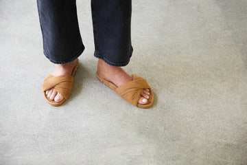 Woman wearing Tesia suede slide sandal in almond with dark jeans