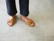 Woman wearing Tesia suede slide sandal in almond with dark jeans