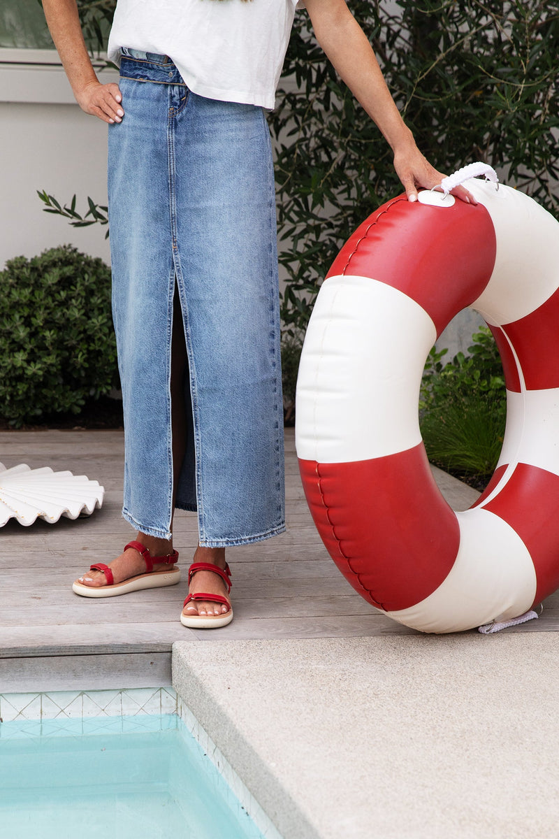 Woman wearing Tyto leather sandal in lipstick with jean skirt by the pool