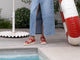 Woman wearing Tyto leather sandal in lipstick with jean skirt by the pool