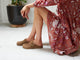 Woman wearing Vulture suede mules in chestnut with floral dress